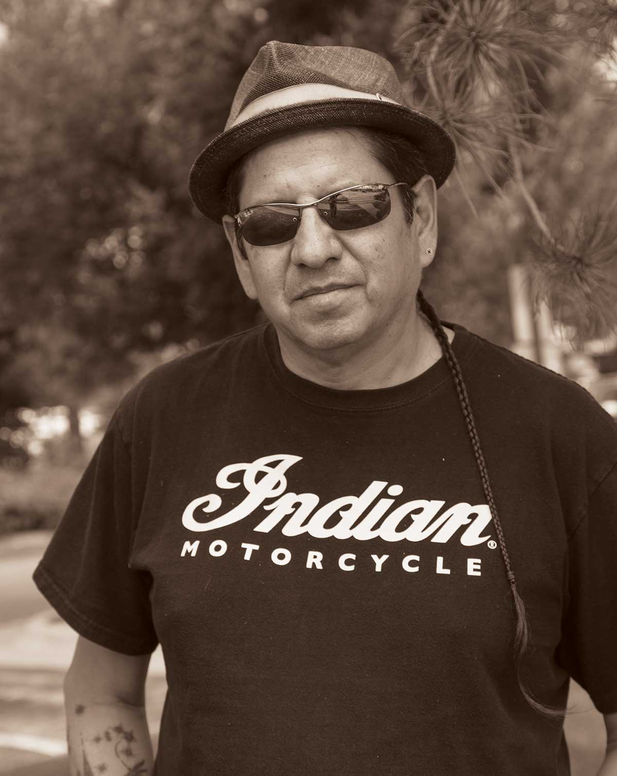 A photograph of a man wearing a hat and sunglasses