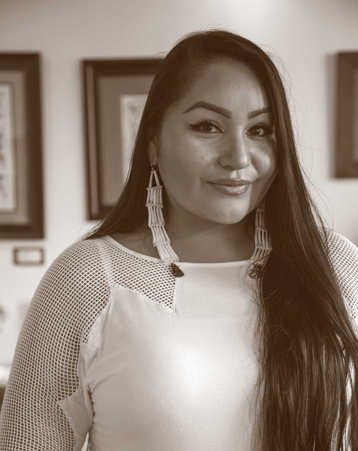 Photograph of a woman with long hair wearing long earrings