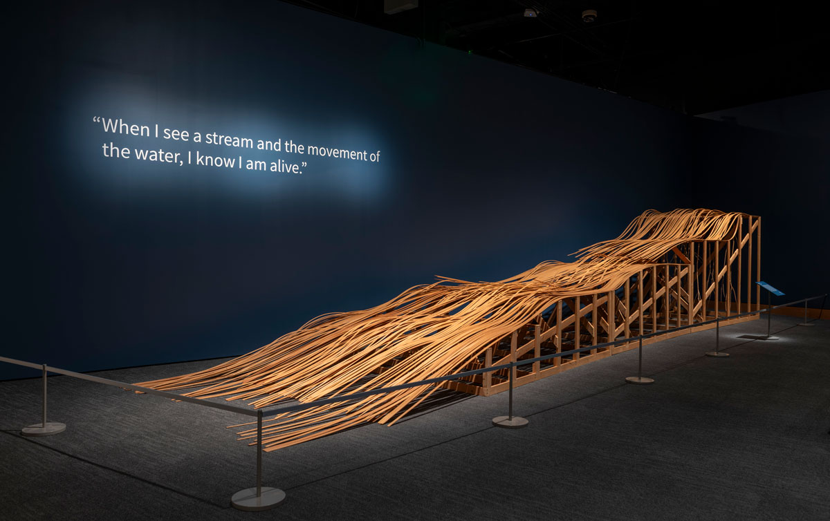 Large wooden sculpture depicting river water rapids