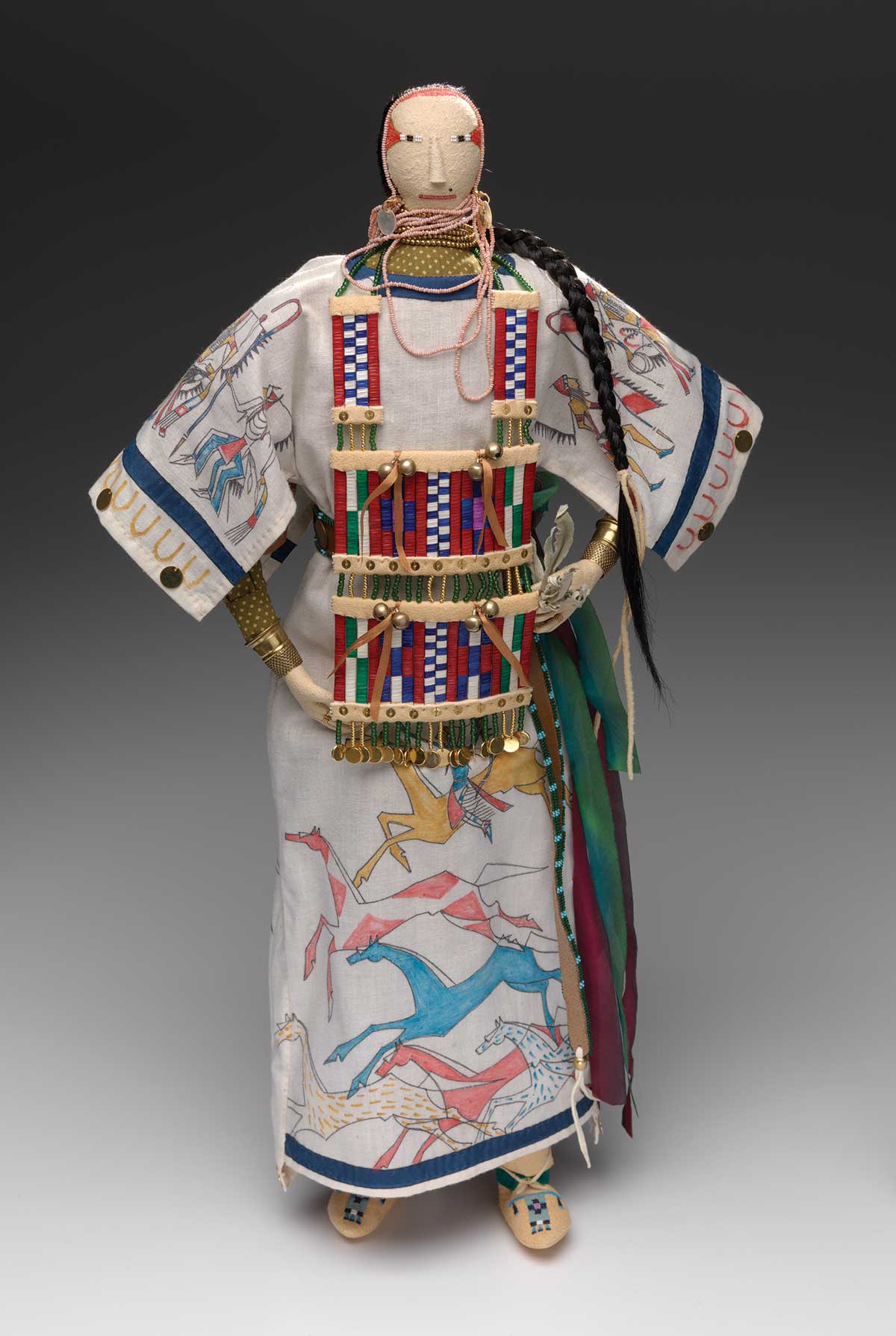 A doll dressed in an honor dress decorated with pictorial symbols