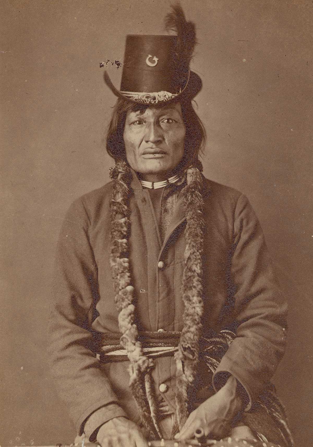 Archival photograph of a seated man in a tall hat