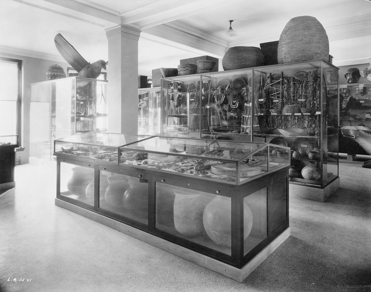 Black and white photo of art and artefacts in display cases