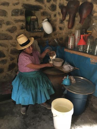 Eucivia Silva pouring chicha de jora in her chicharia