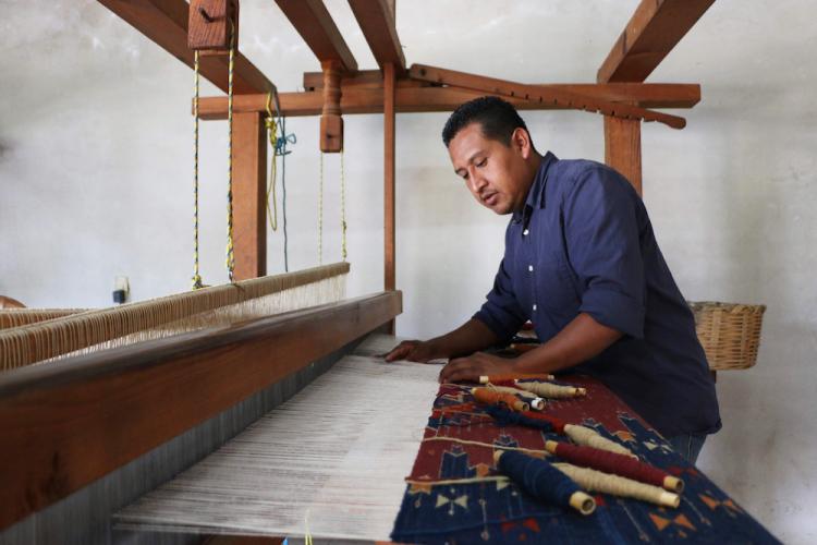 Porfirio Gutierrez weaves a textile with a traditional Zapotec design using a nine-thread-count-per-inch comb loom.
