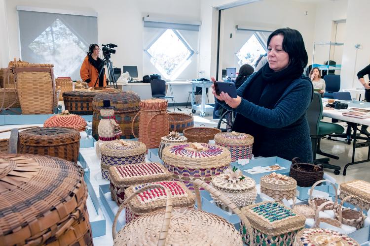 Jennifer Neptune taking photo of baskets