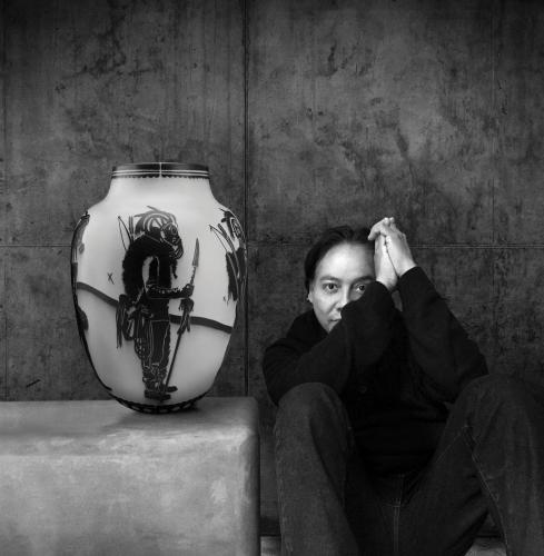 Artist Virgil Ortiz sits with one of his traditionally made Cochiti Pueblo pots depicting one of his "Recon Watchmen" characters.