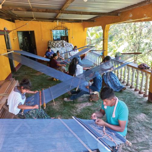 Weavers work on a porch in Guatemala.