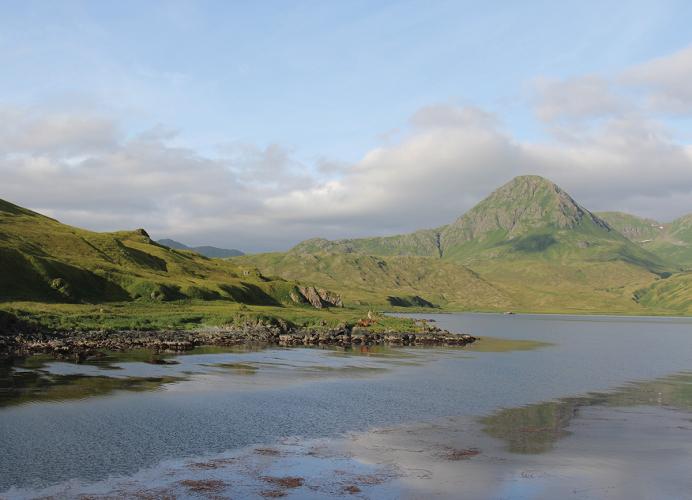 A landscape photograph of the island where the mountain reaches the water.