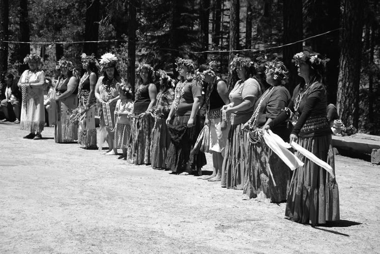 A black and white image of a line of women participating in the Bear Dance.