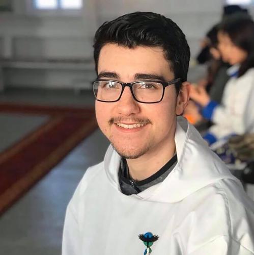 A portrait of a young man, Nicholas Flowers, who is wearing glasses and a hooded sweatshirt