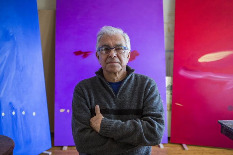 Portrait of Robert Houle in front of his paintings.