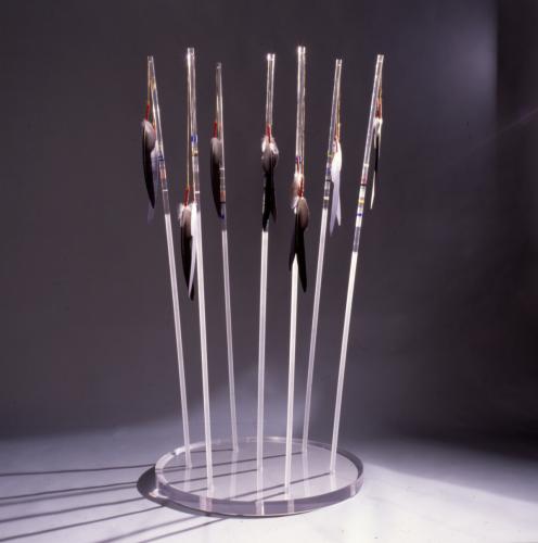 A sculpture featuring lances placed in a circle on a clear stand
