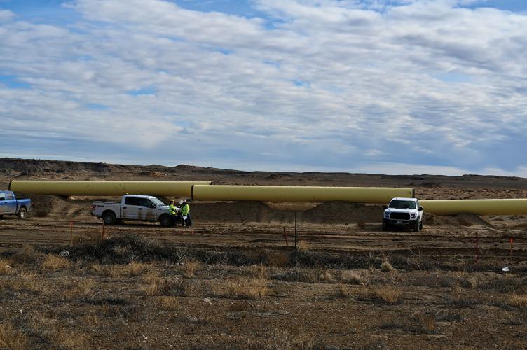 Photo of trucks and pieces of pipeline