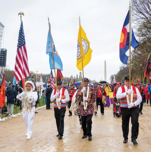 Four men carry flags in procession