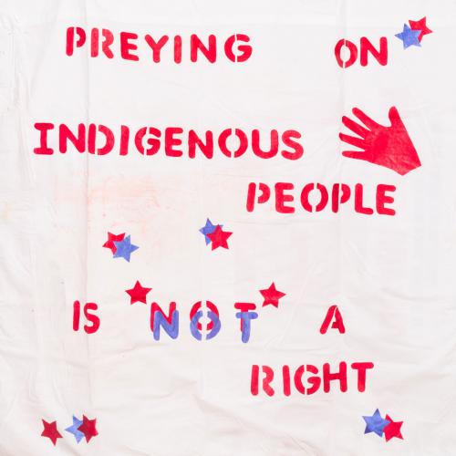 Closeup of a quilt piece with the words "Preying on Indigenous People is Not a Right"