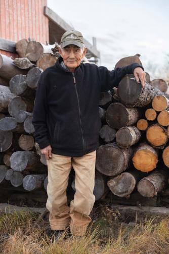 Jacob Black standing near stacked logs.