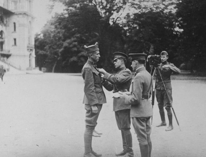 The Distinguished Service Cross is pinned to the lapel of a soldier by an office.
