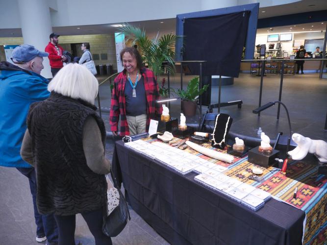 A vendor talks to visitors at the Native Art Market.