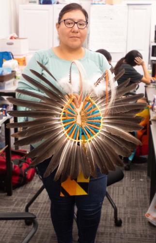 Lakota artist holds her completed bustle.