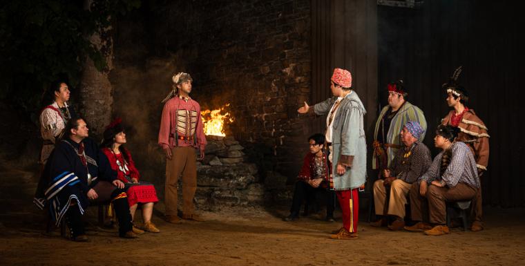A scene from Unto These Hills depicts a tense discussion between Tecumseh and Cherokee leaders in front of a roaring fire.